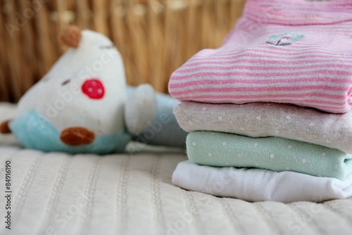 Pile of baby clothes and a toy