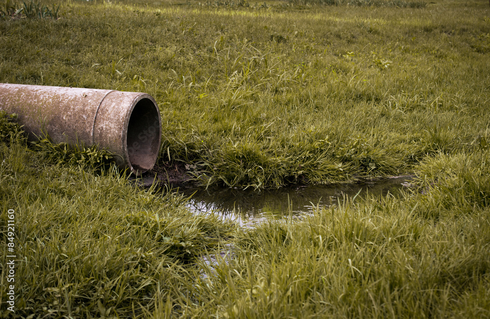sewer pipe to waste water on the green grass sewer pipe to waste water on the green grass