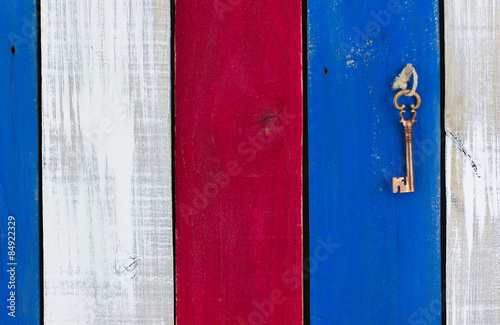 Skeleton key hanging on red, white and blue wood background