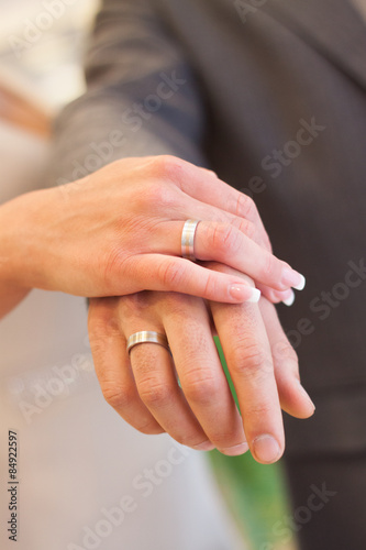 Bride and groom wedding rings on hands.