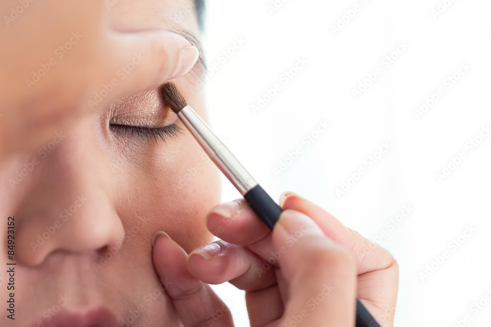 eye makeup with brush on pretty woman face