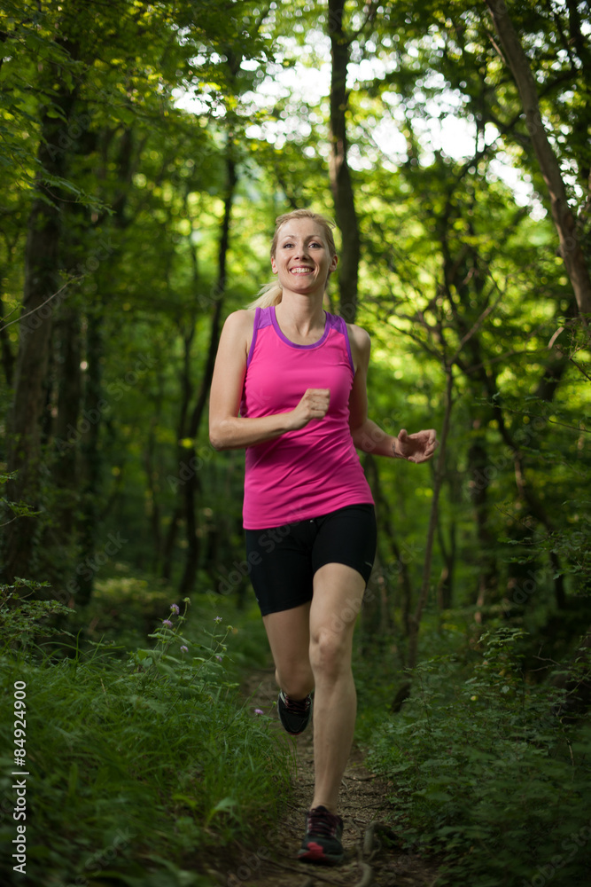 Beautiful young woman runns on forest  path