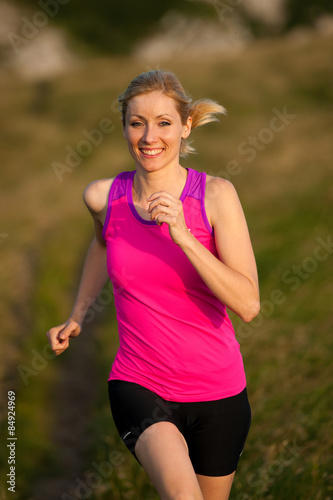 beautiful young woman runns cross country on a mountian path at