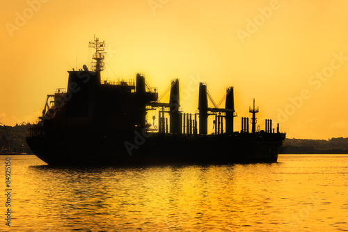 Commercial cargo ship at sunset