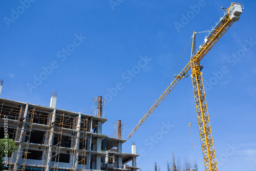 yellow construction cranes above blue sky