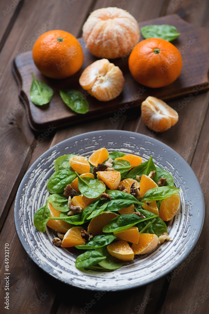 Salad with spinach, mandarins and walnuts, studio shot