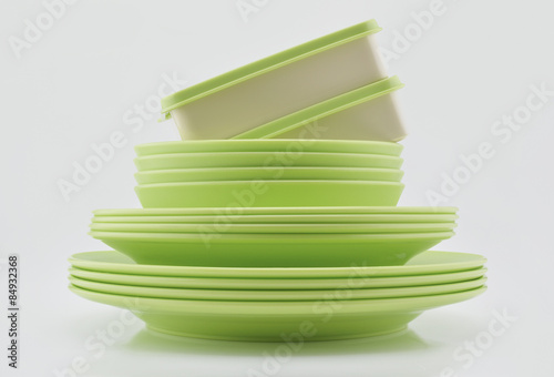 Green plastic plates, bowls and boxes isolated on white backgrou