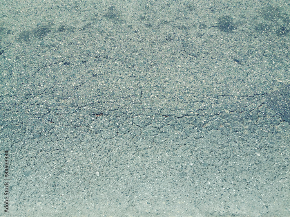 Texture of old asphalt with cracks closeup, grunge background