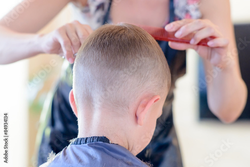 Hairdresser cutting a young boys hair