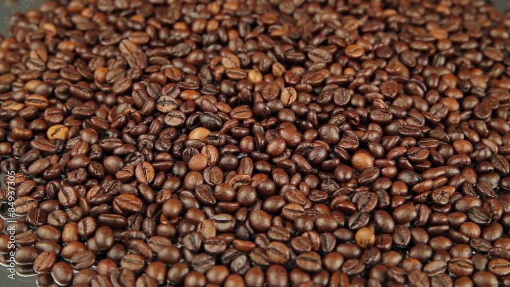 Roasted coffee beans rotates on the table. Roasted coffee beans rotates on the table.