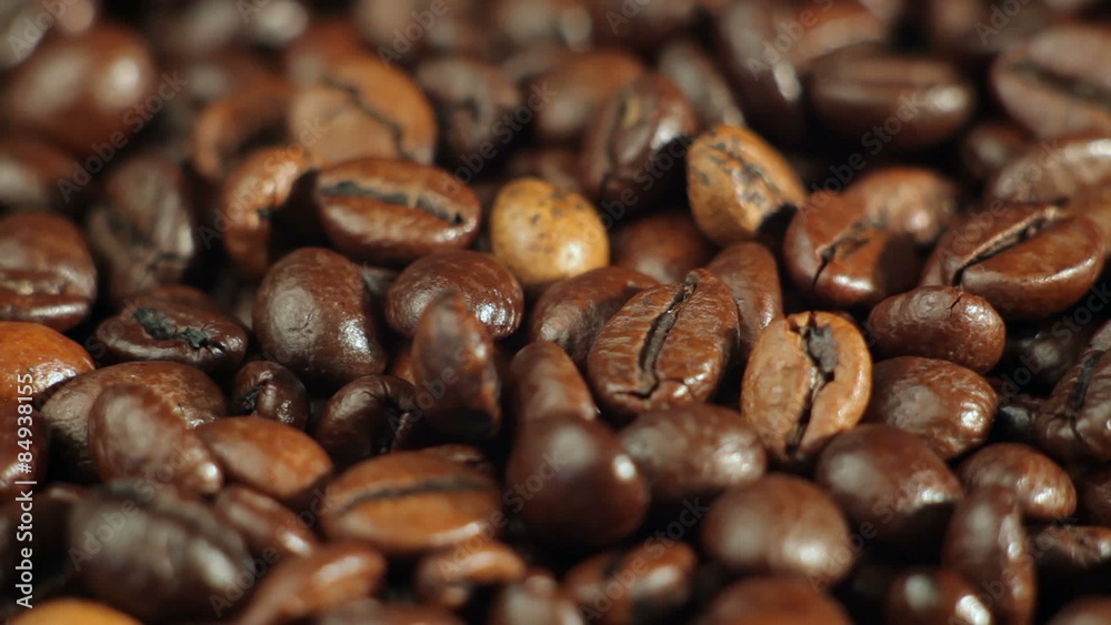 Roasted coffee beans rotates on the table. close-up Roasted coffee beans rotates on the table. close-up