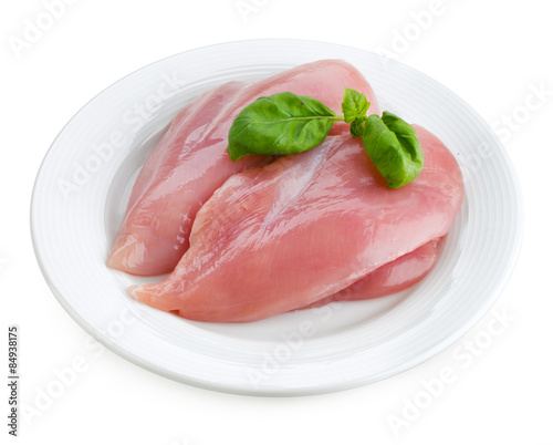 Raw fresh chicken fillet with basil isolated on white plate.