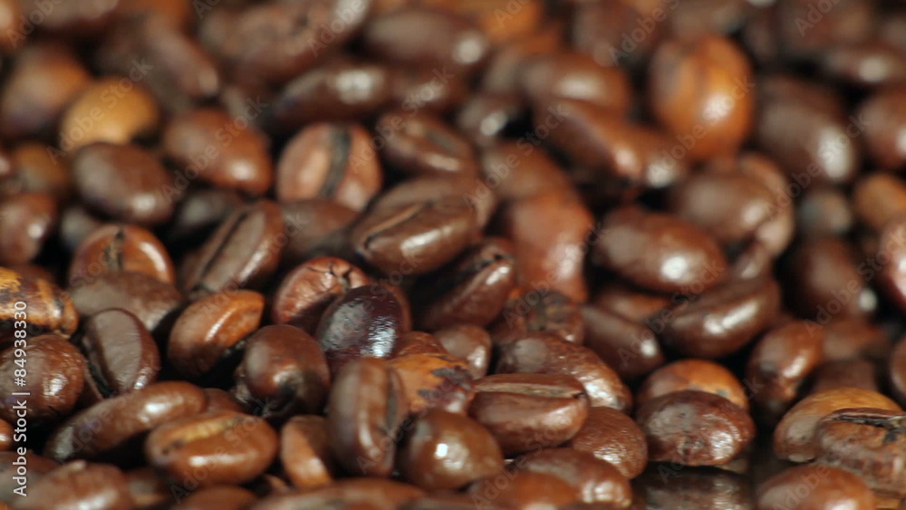 Roasted coffee beans rotates on the table. close-up Roasted coffee beans rotates on the table. close-up