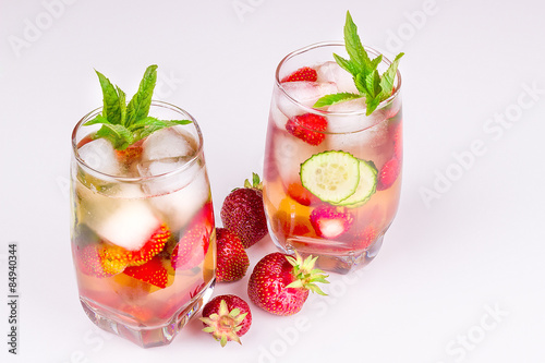 strawberries in bulk on a white background, a glass with a drink