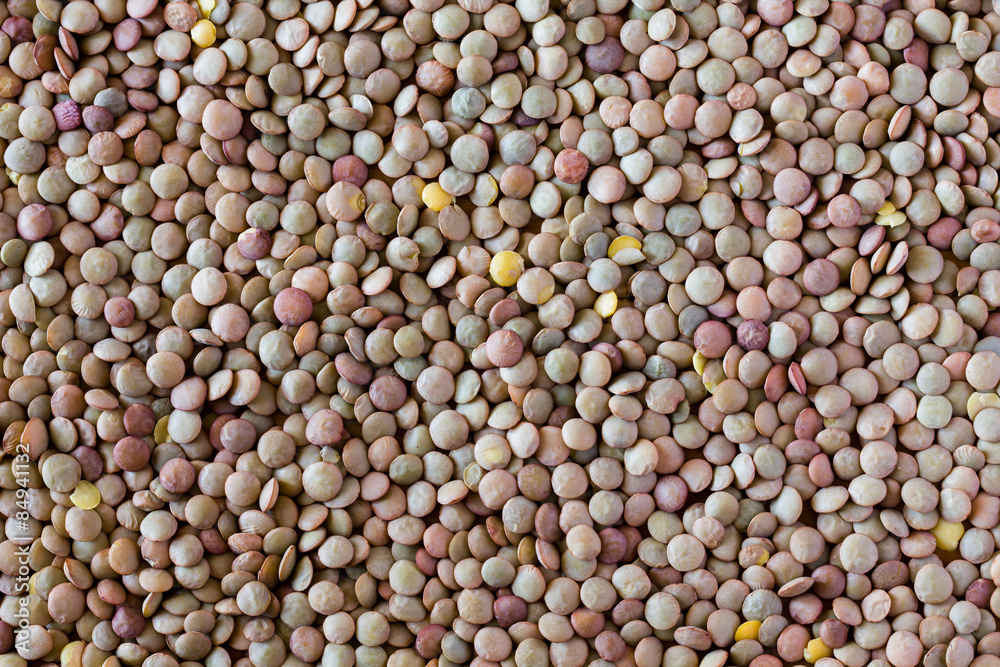 Cooking lentils spilled on the table as a background. Cooking lentils spilled on the table as a background.