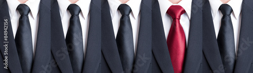 Red tie between black neckties photo