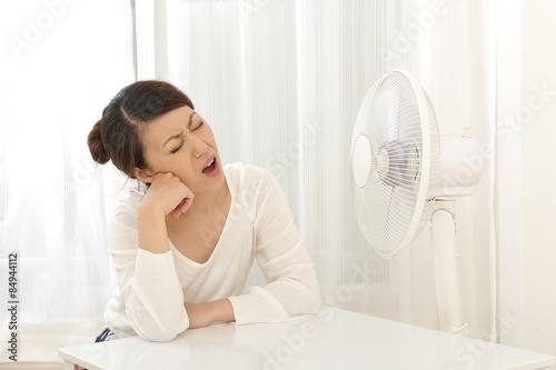 扇風機の風で涼しんでいる日本人女性