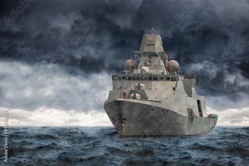Obraz Wojskowy statek na morzu przed ciężkimi chmurami.
