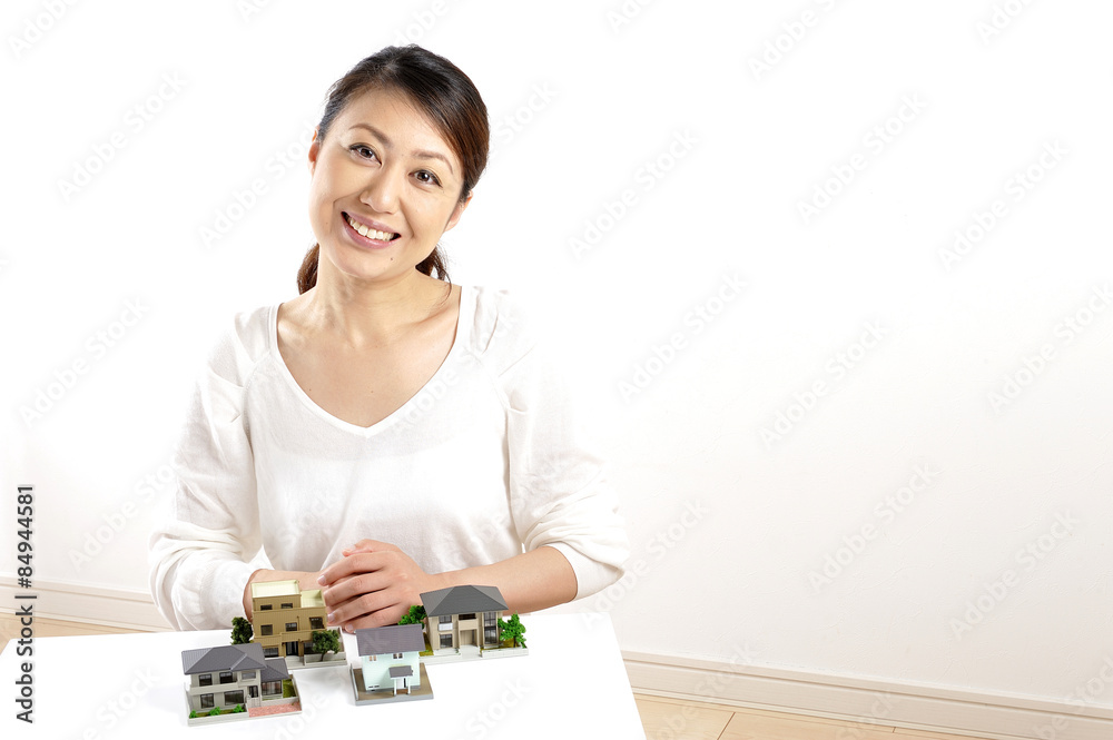 住宅の模型を説明している日本人の綺麗な女性 住宅の模型を説明している日本人の綺麗な女性