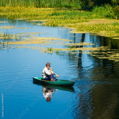 Fényképezés Elderly Man Fishing On River Boat
