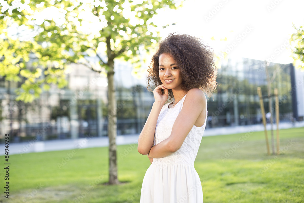 Enjoyment - free happy american african woman with afro enjoying sunset. Beautiful woman in white dress embracing the golden sunshine in the city Enjoyment - free happy american african woman with afro enjoying sunset. Beautiful woman in white dress embracing the golden sunshine in the city