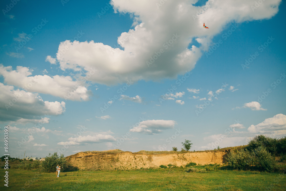 lovely couple play with air kite at green meadow