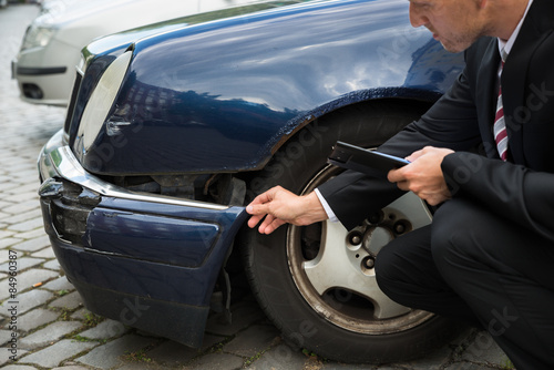 Insurance Expert Examining Car Damage