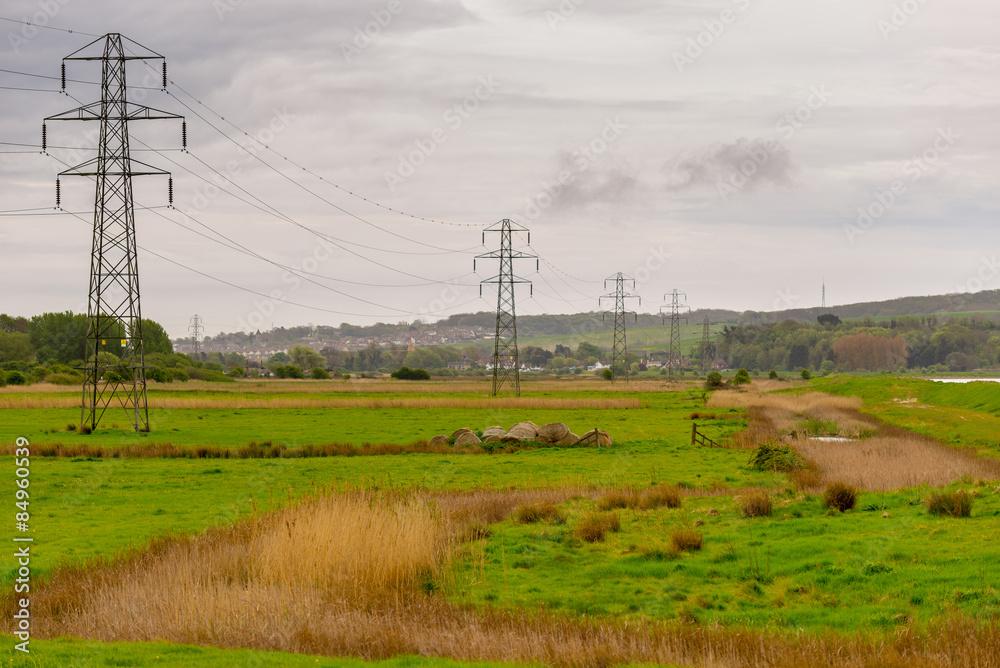 Electricity pylons stretching into the distance across a rural landscape.
