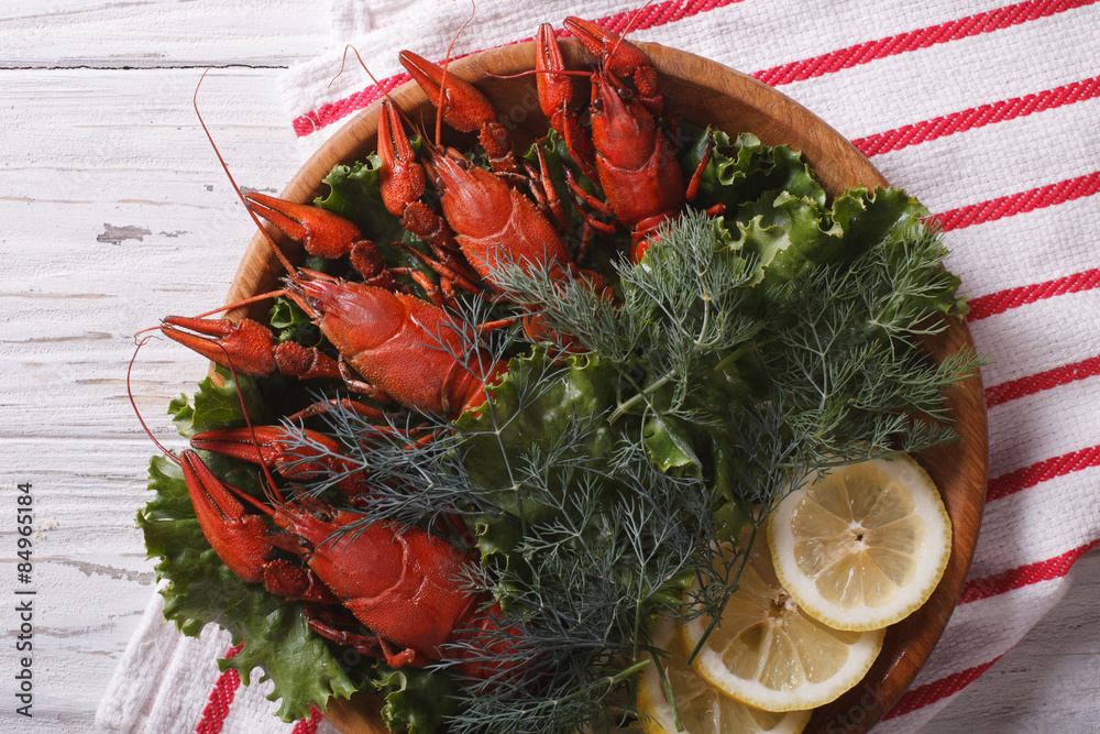 crayfish with herbs and lemon on a plate. Horizontal top view closeup
