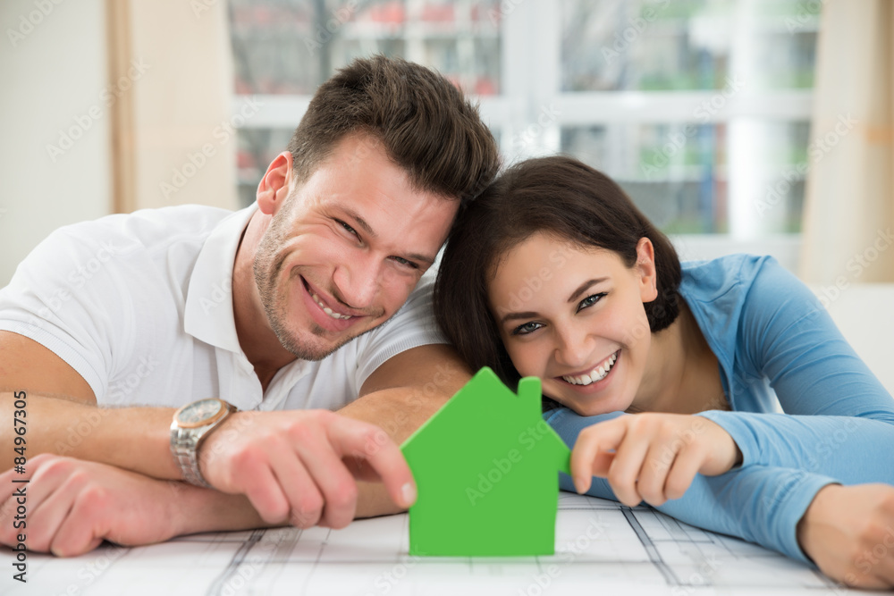 Young Couple Holding Green House Model Young Couple Holding Green House Model