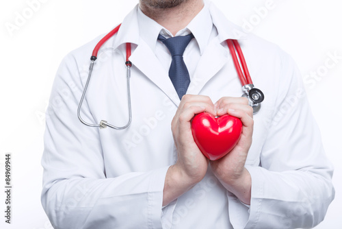 Nice cardiologist holding heart photo