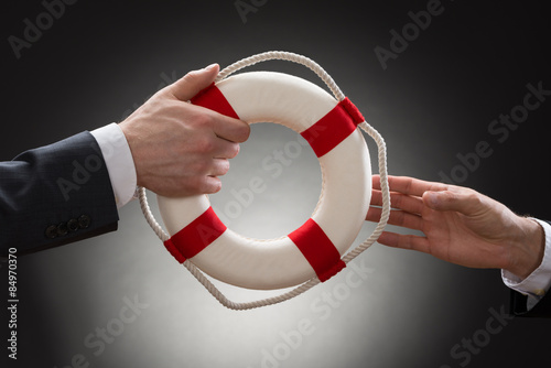 Close-up Of A Male's Hand Holding Lifebuoy photo