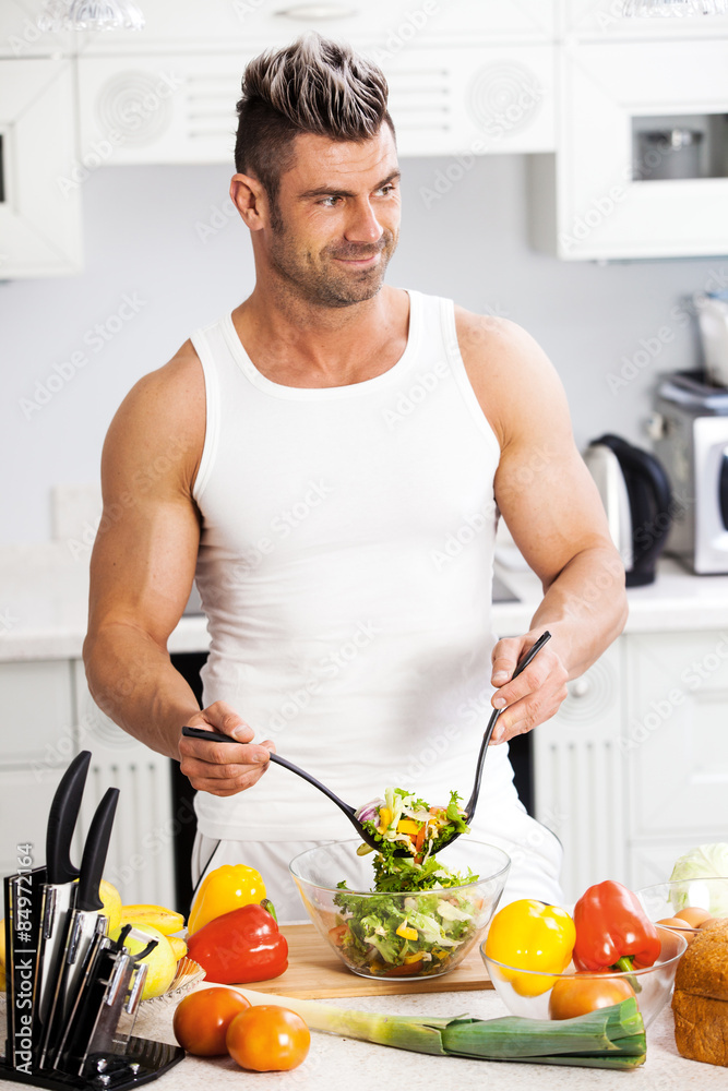 Happy handsome man cooking in kitchen at home. Happy handsome man cooking in kitchen at home.