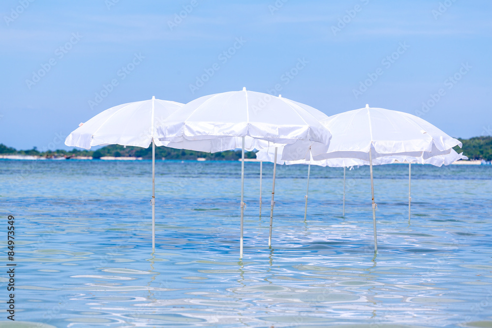 White umbrella on summer tropical beach with sailing boat. White umbrella on summer tropical beach with sailing boat.