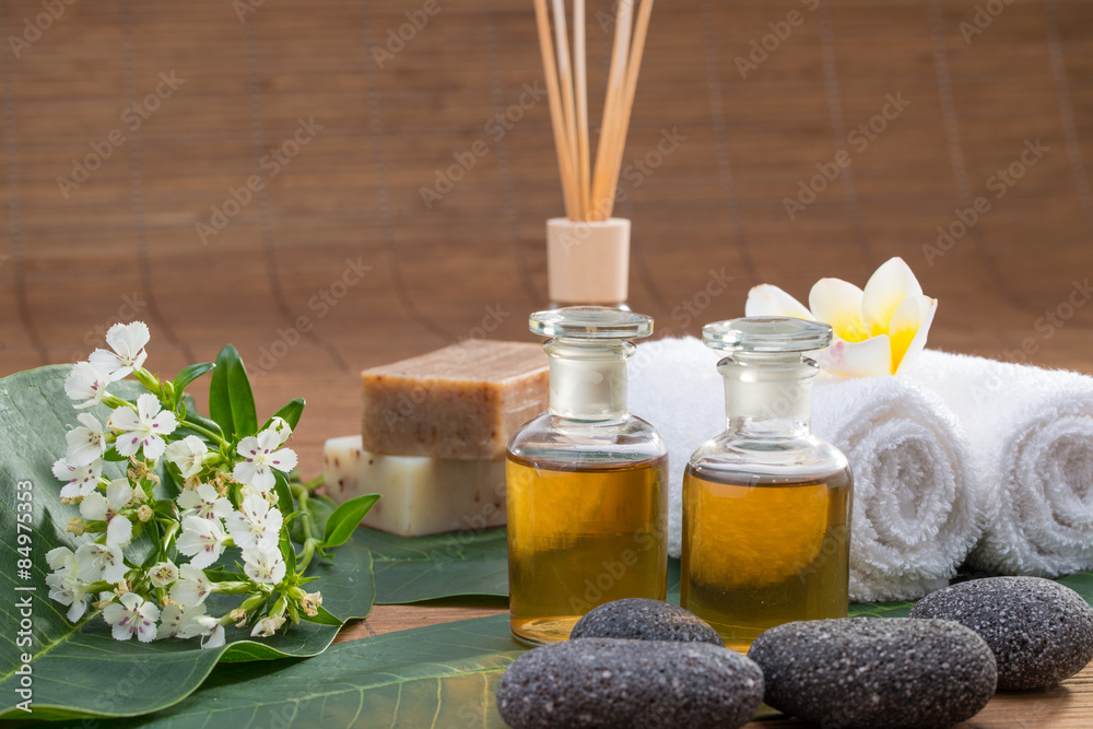 Essential Oil, flower, pebble stone on green leaf, white towel, Essential Oil, flower, pebble stone on green leaf, white towel,