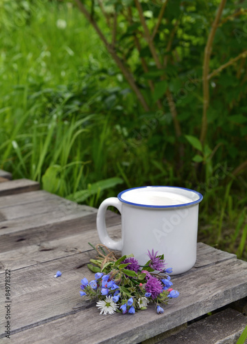 Summer still life with milk in mug and wildflowers 