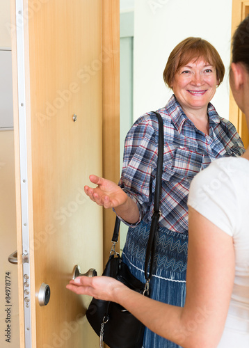 Cheerful greeting of two women at the door photo