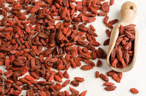 Goji berry dried in a dish, with spoon, closeup background