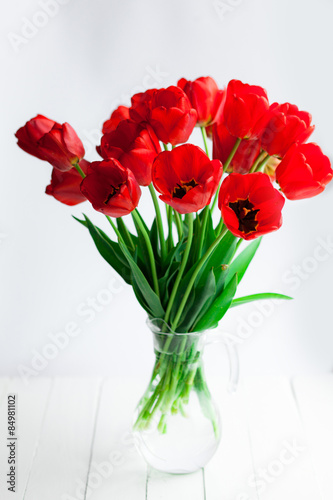 Red tulips glass gar on wood table
