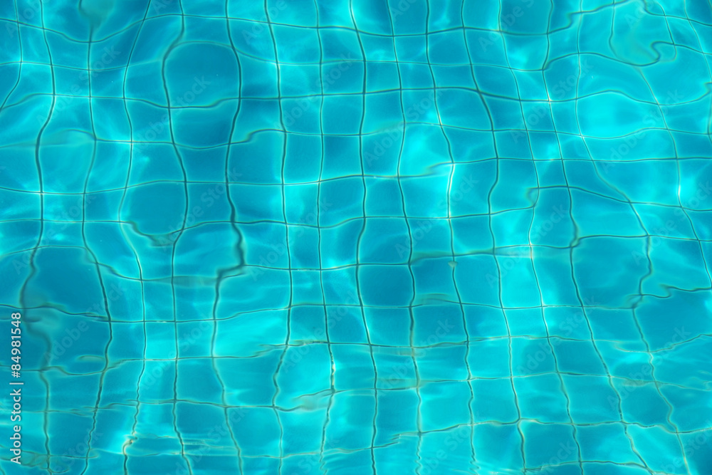 blurred blue water ripple over ceramic floor of swimming pool