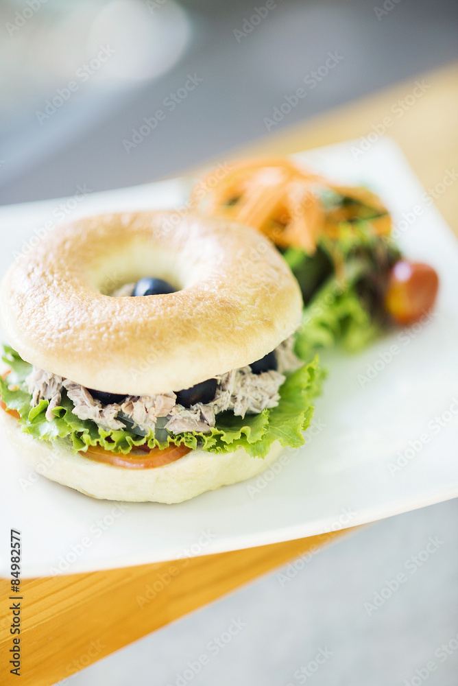 tuna and olive bagel with mixed salad