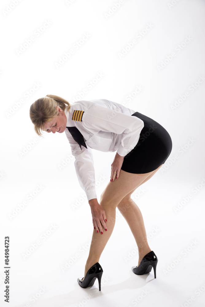 Obraz premium Attractive female airline pilot checking her tights prior to going on duty