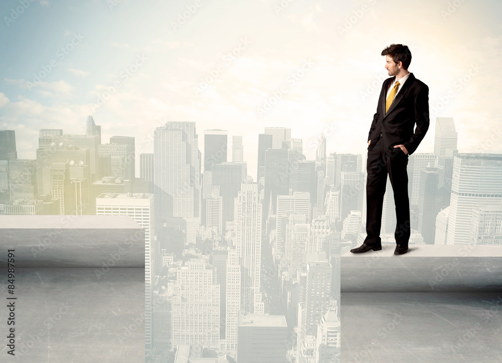 Businessman standing on the edge of rooftop Businessman standing on the edge of rooftop