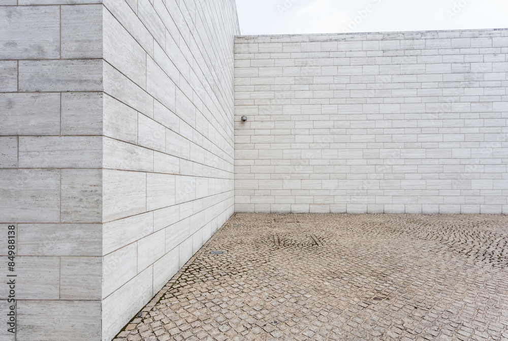 Fototapeta premium white brick wall and empty sandstone road