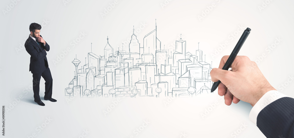 Businessman looking at hand drawn city on wall Businessman looking at hand drawn city on wall