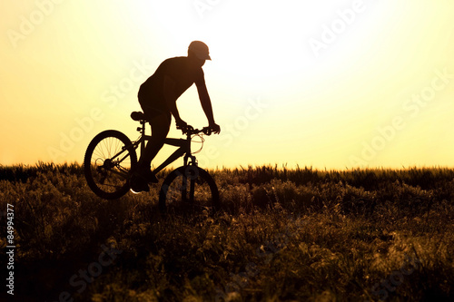 silhouette of a Man riding a bicycle in the field