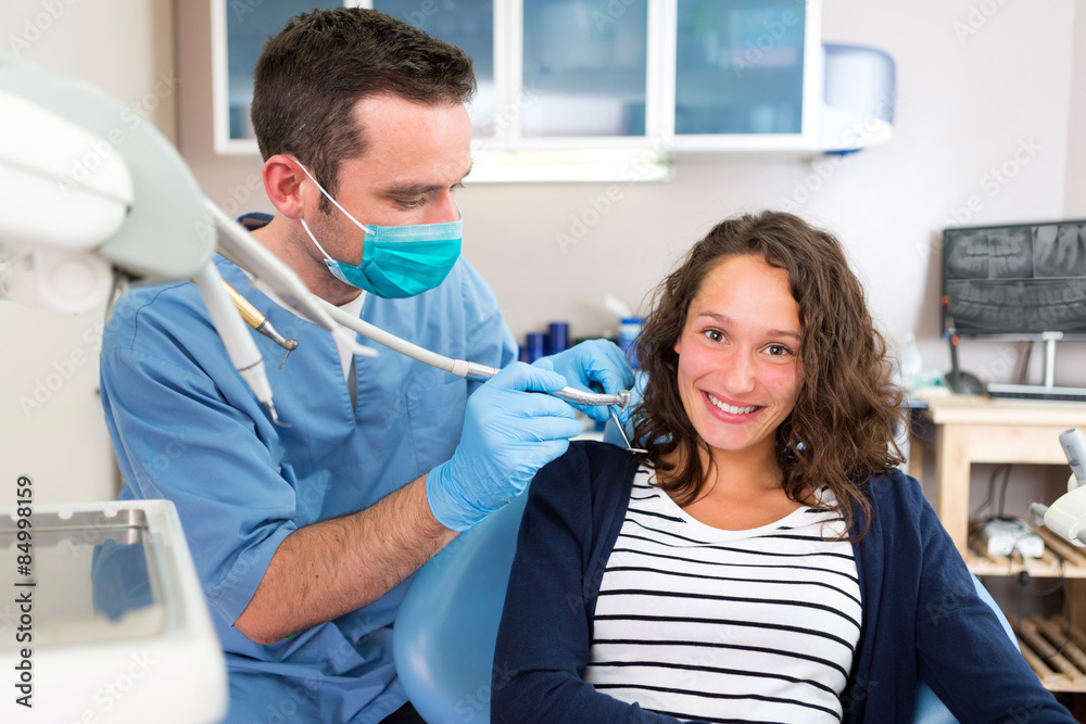 Fototapeta premium Young attractive woman being cured by a dentist