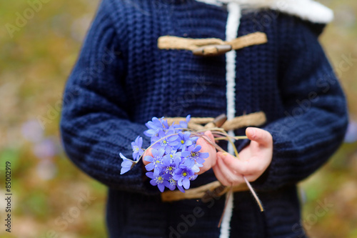 Adorable girl picking the first flowers of spring