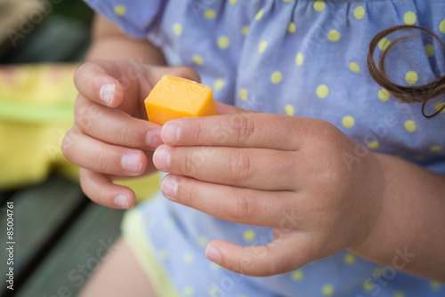 チーズを持つ子供の手