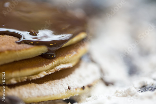 Stack of pancakes smothered in chocolate sauce